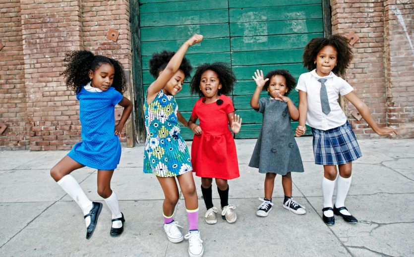 Girls dancing on city sidewalk