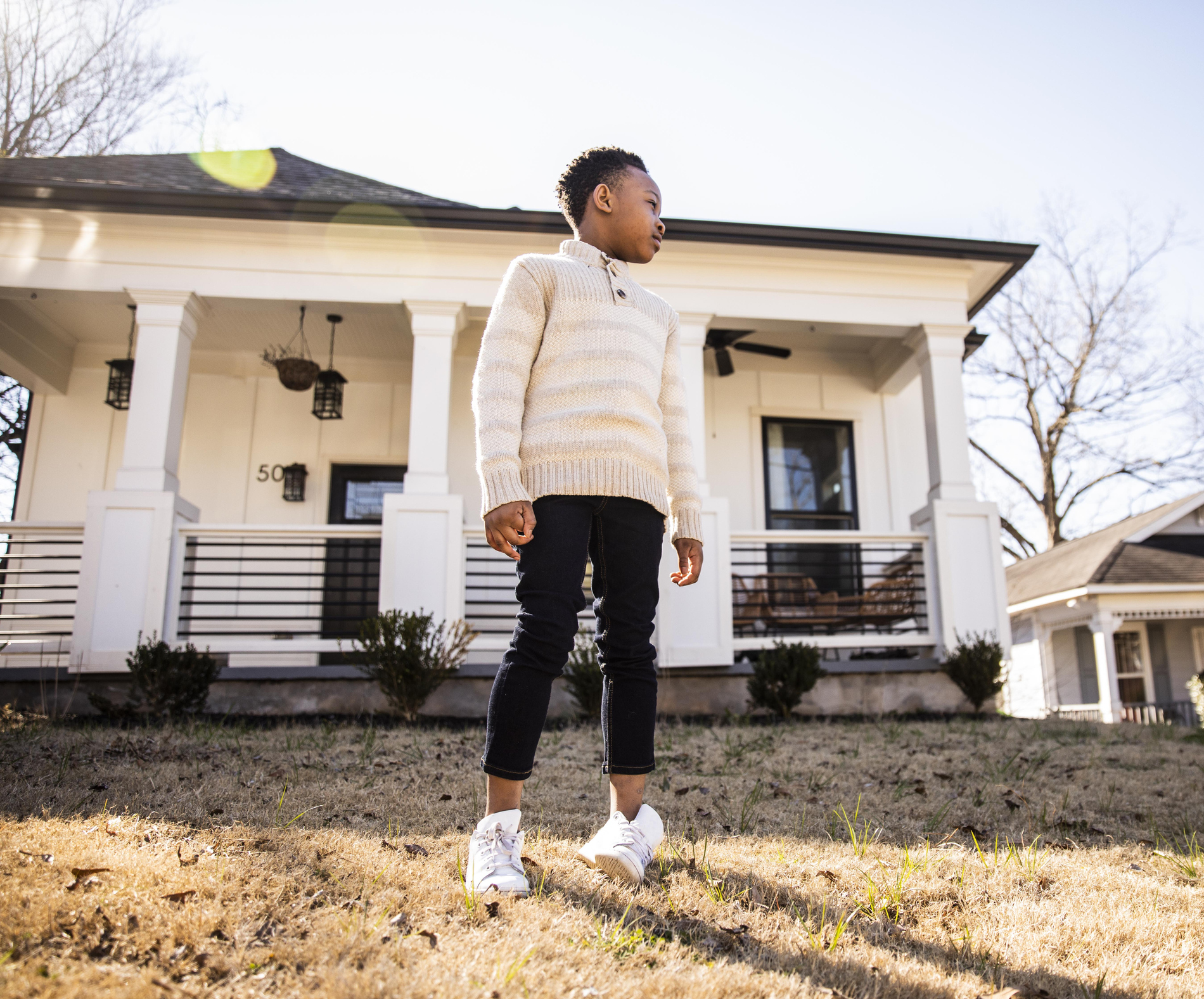 Portrait of young boy in front of home